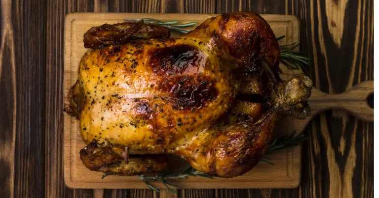 "Close-up of a Perfectly Roasted Chicken Garnished with Fresh Herbs"