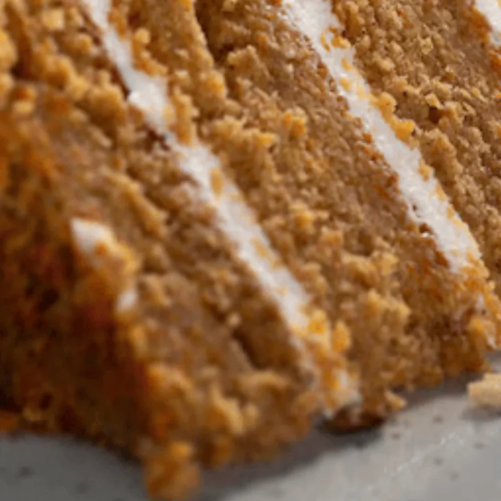 A delicious slice of carrot cake topped with creamy cheese