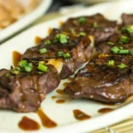 A close-up shot of juicy Garlic Butter Steak Bites with a rich golden garlic butter sauce, garnished with fresh parsley.