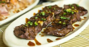 A close-up shot of juicy Garlic Butter Steak Bites with a rich golden garlic butter sauce, garnished with fresh parsley.