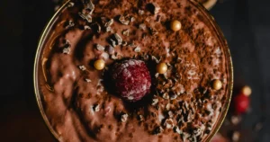 A serving of Belgian chocolate mousse topped with chocolate shavings, cocoa powder