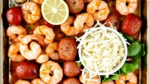 Sheet pan shrimp boil with shrimp, sausage, corn, and potatoes roasted on a baking sheet.