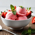 A bowl of homemade Strawberry Sorbet garnished with fresh mint leaves and sliced strawberries, placed on a rustic wooden table.