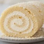 A sliced Japanese Cake Roll filled with whipped cream, showcasing the soft and fluffy sponge cake with a swirl pattern.